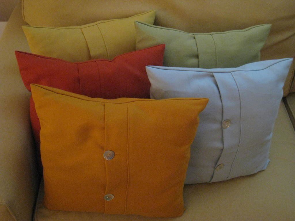 Stack of colourful cushions in mustard, coral, sage and sky blue