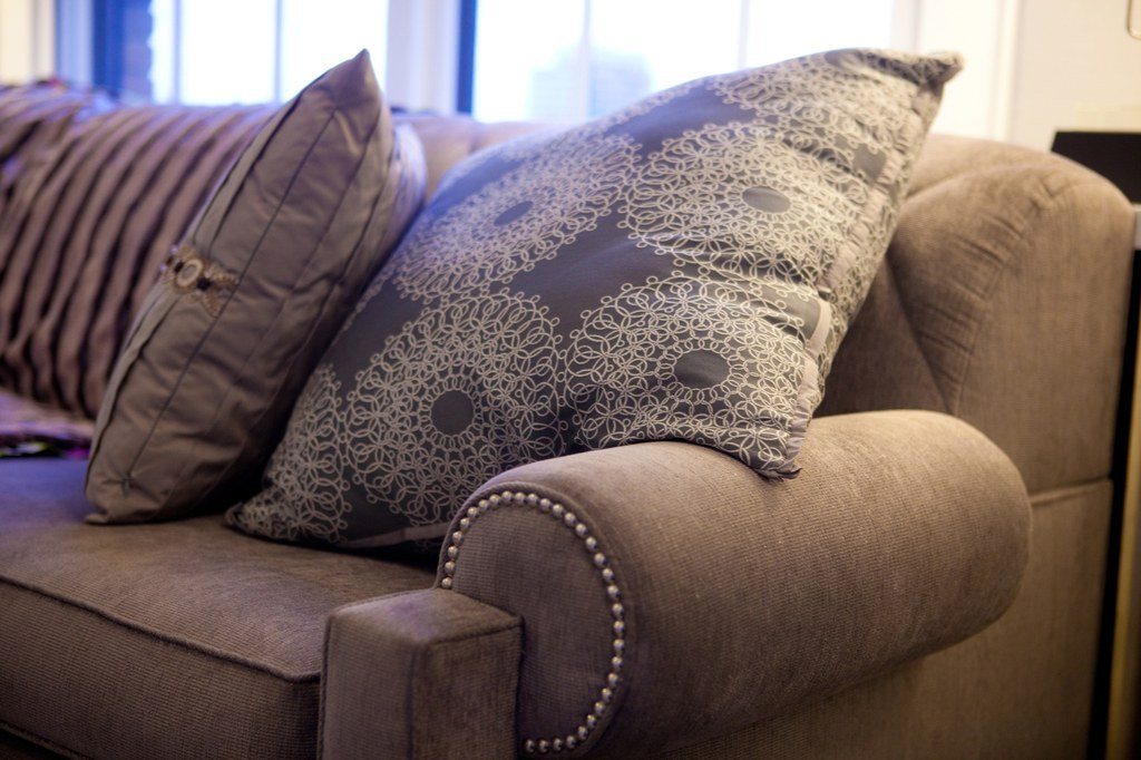 Soft grey sofa dressed with patterned and plain throw pillows