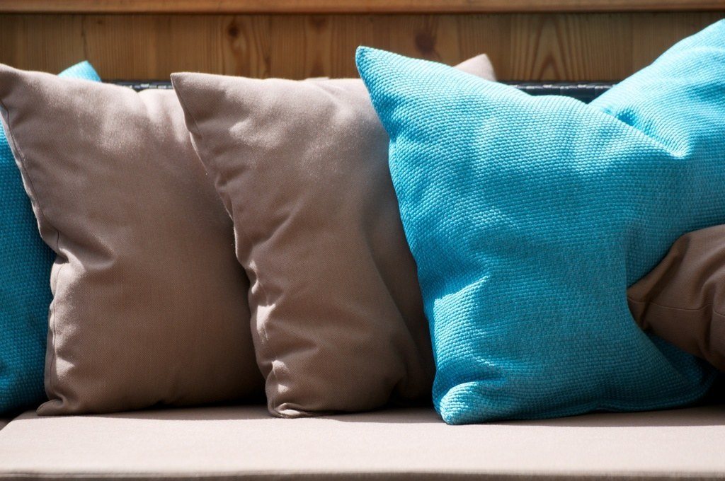 Teal and taupe cushions on a sofa